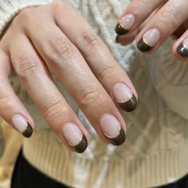 濃いブラウンを先端だけにのせ、境目に細いゴールドを入れたフレンチネイル