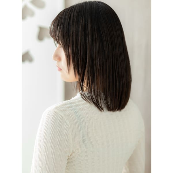 襟足に面を残した黒髪のハッシュカット（鎖骨あたりのミディアム・後ろ姿）