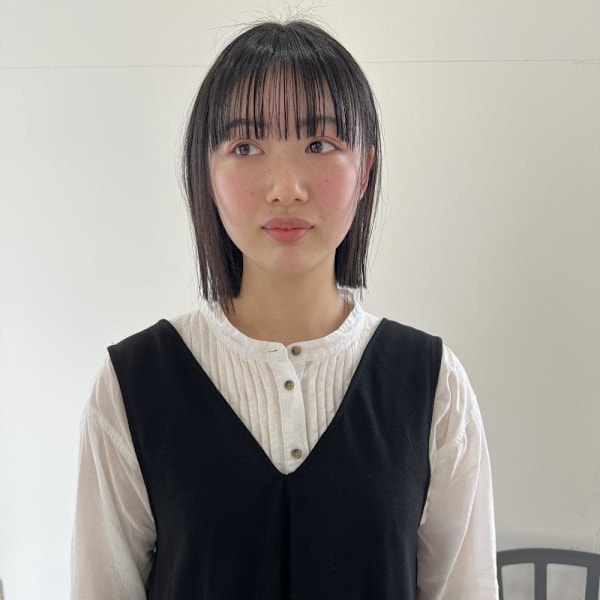 あご下でそろえた黒髪ボブ、ぱっつん前髪で顔まわりに段差を入れたハッシュカット