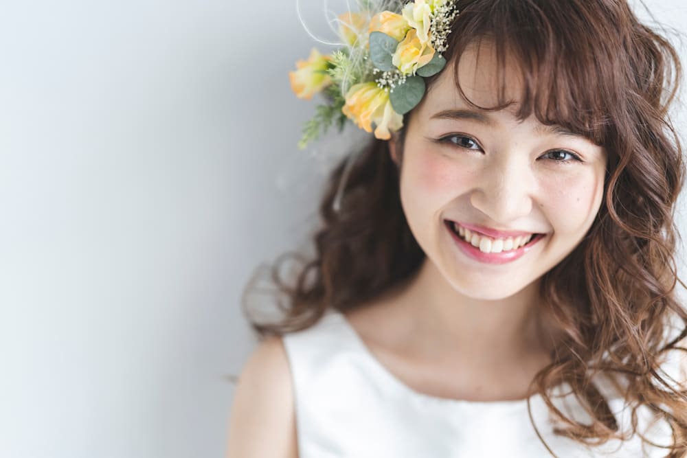 頭に花をつけたパーマヘアの女性