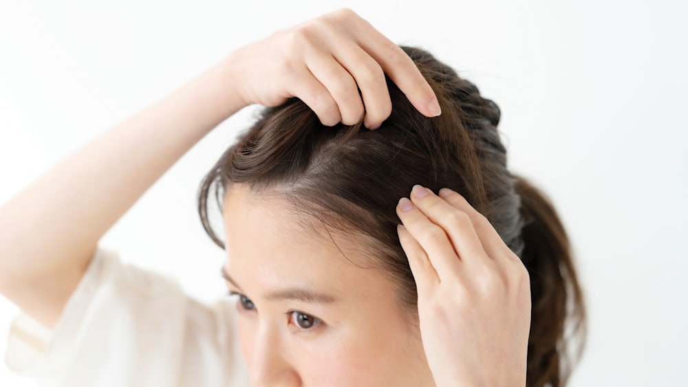 白髪を探す女性