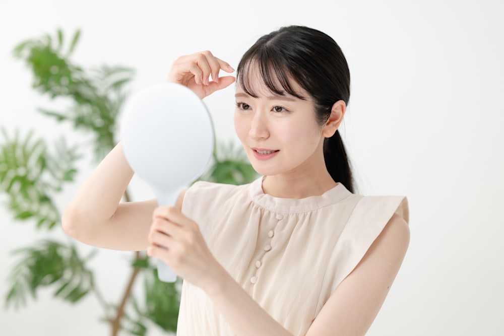 前髪を鏡で確認する女性