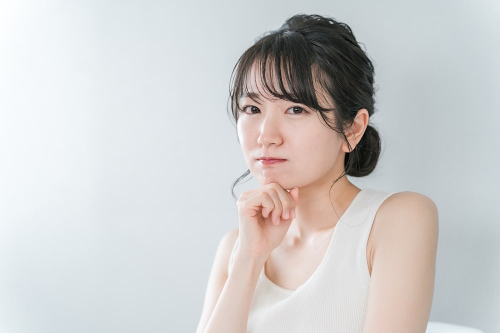 顎に手を添え考える女性