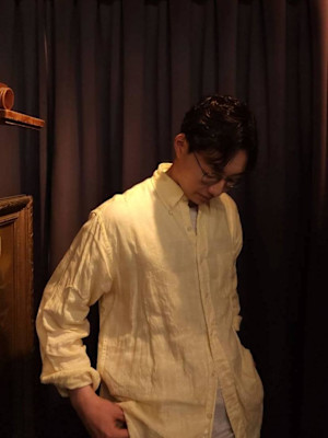 パーマありのセンターパートの前下がりのショートヘアー